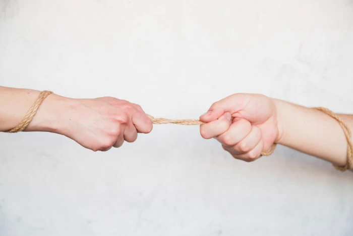 main tirant une corde rivalité